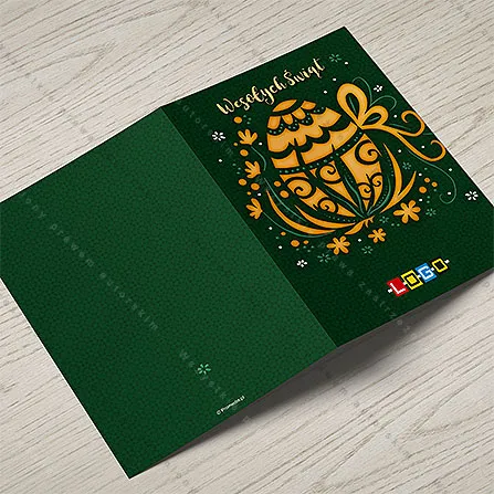 Karnet WN1-063 Złoty ornament na leśnej zieleni, otwarty na stole, środek z miejscem na życzenia i logo