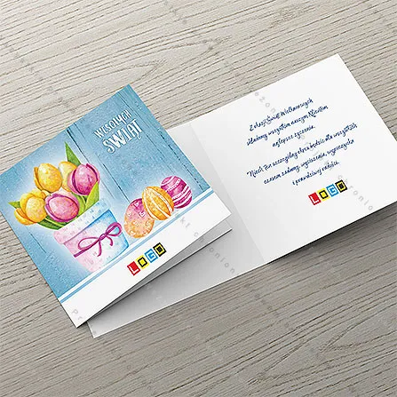 Tulipany w pastelowej donicy z fioletową tasiemką, obok jaja w serduszka i paski, w tle postarzane niebieskie deski