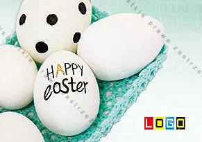 Białe jajka w turkusowym pudełku od góry, na największym z nich odręcznie wypisano HAPPY Easter